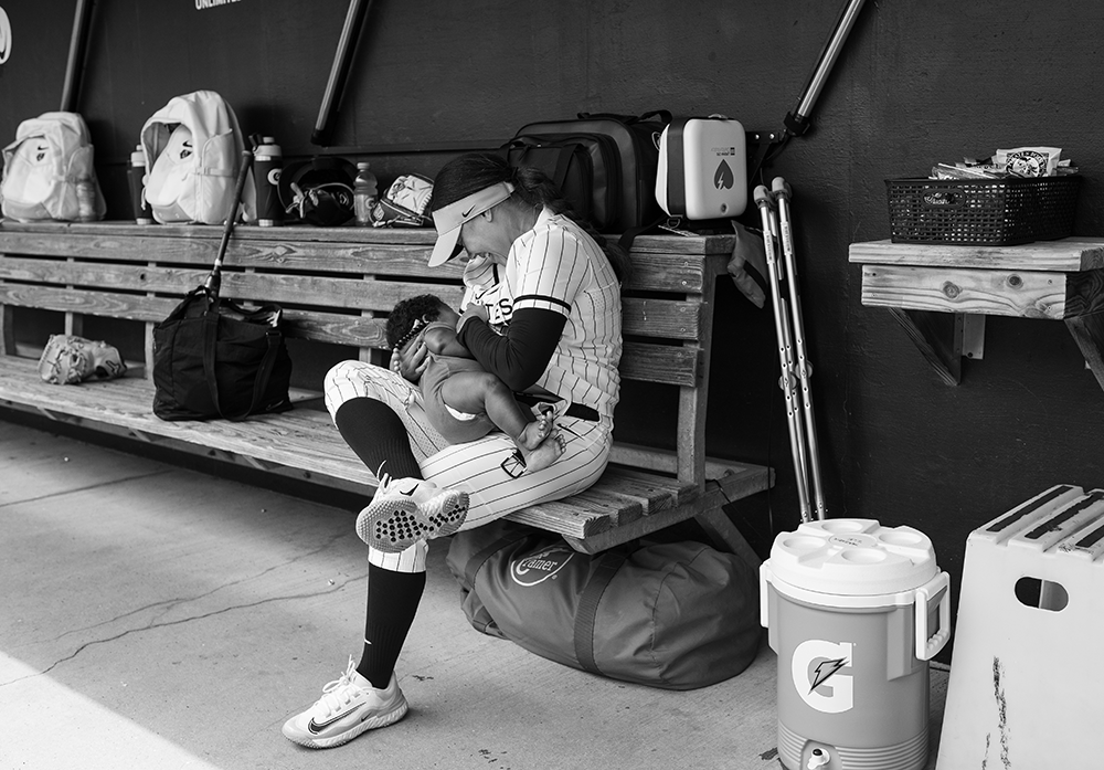 Kelsey Stewart-Hunter breastfeeding her son in the dugout before an Athletes Unlimited Softball game.