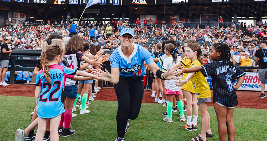 Morgan Zerkle in a blue Chicago Bandits uniform runs through the fans high five line